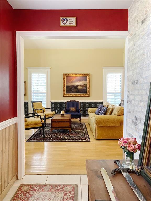 A view from a tiled entryway into a living room with hardwood floors and yellow furniture — 27 LAKE VISTA WAY, ORMOND BEACH, FL