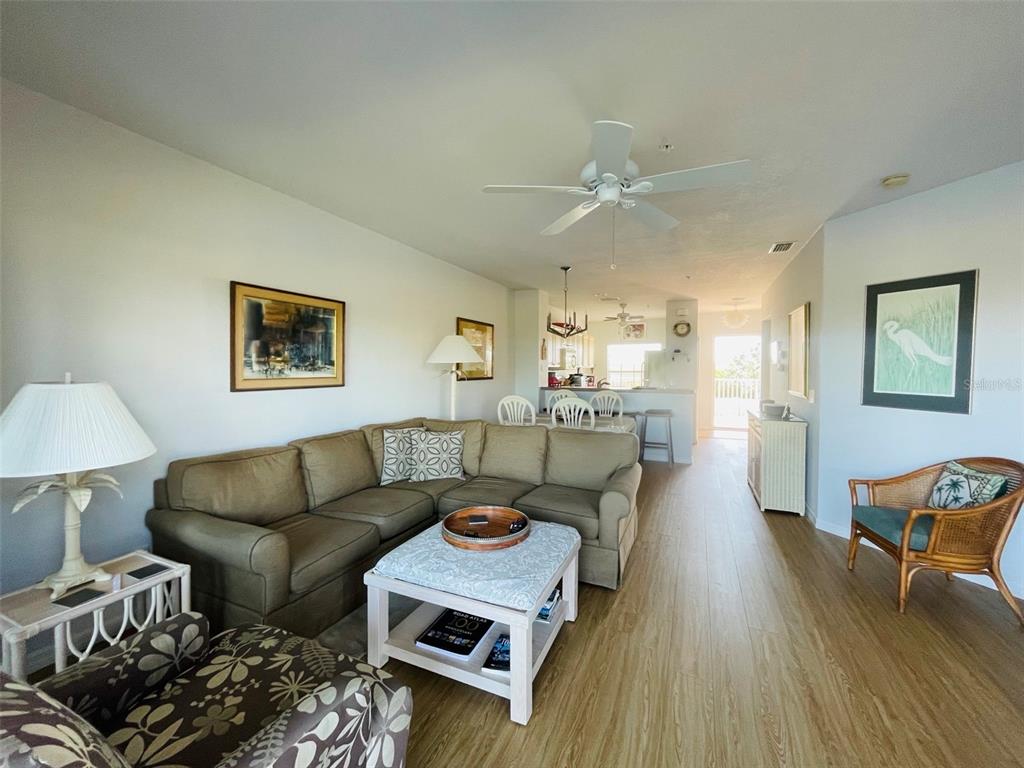 A living room features a sectional sofa, a coffee table, and light wood-look flooring — 2040 WILLOW HAMMOCK CIRCLE UNIT 202, PUNTA GORDA, FL