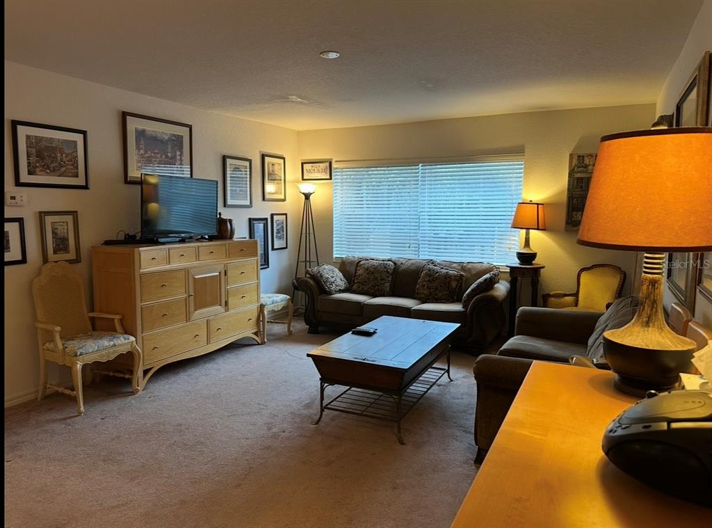 A living room featuring a wooden dresser, a sofa, a coffee table, and framed wall art — 4600 E MOODY BOULEVARD UNIT 3J, BUNNELL, FL