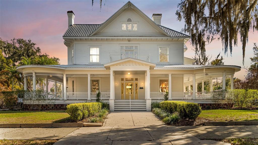 A two-story white historic house features a wraparound porch and a central front entrance — 555 E STANFORD STREET, BARTOW, FL