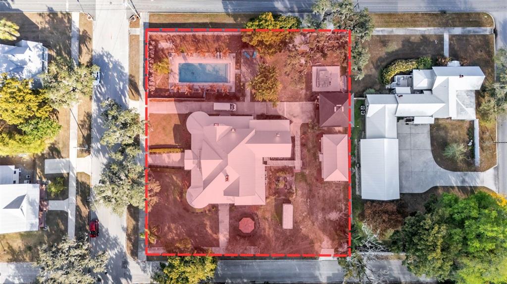 Aerial view of a residential property featuring a large house, swimming pool, and detached structures — 555 E STANFORD STREET, BARTOW, FL