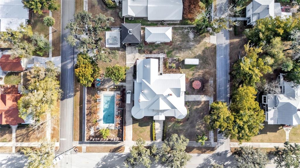 An aerial view shows a house with a metal roof, a pool, and surrounding trees — 555 E STANFORD STREET, BARTOW, FL