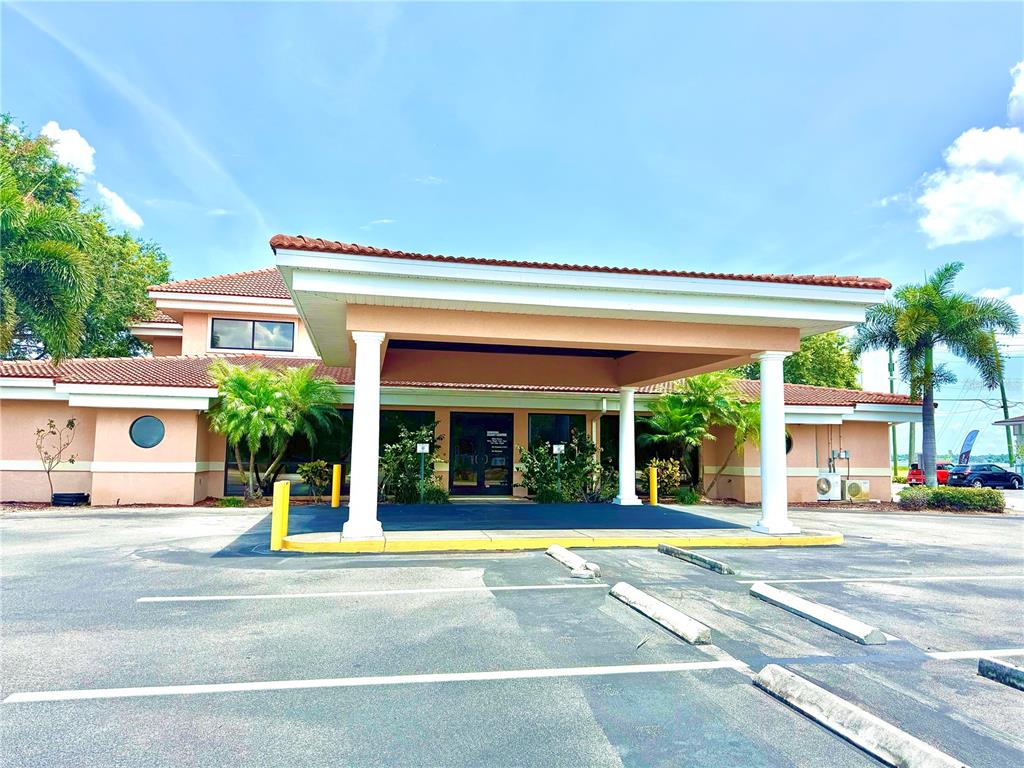 A low-rise commercial building features a large covered entryway supported by white columns — 2237 US HIGHWAY 27 S, SEBRING, FL