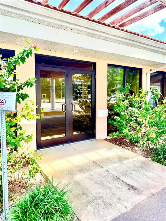 The exterior entrance of the Sebring Heart Center features glass double doors under a pergola — 2237 US HIGHWAY 27 S, SEBRING, FL