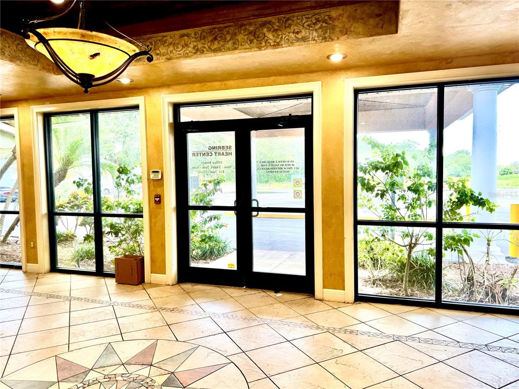 A tiled lobby features a decorative floor inlay, a hanging light fixture, and glass doors — 2237 US HIGHWAY 27 S, SEBRING, FL