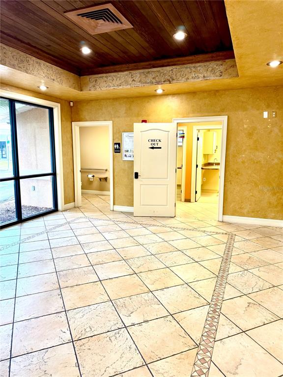 A tiled lobby features a wood-paneled ceiling, a large window, and two doorways — 2237 US HIGHWAY 27 S, SEBRING, FL