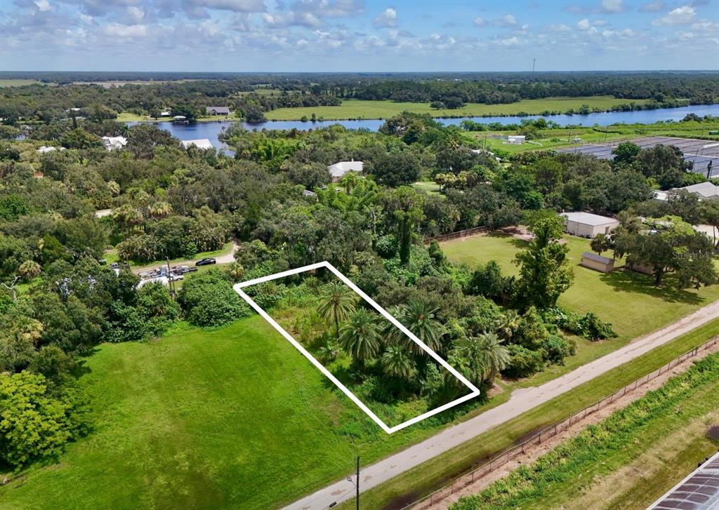 An aerial view shows a rectangular vacant lot outlined in white next to a road — 20101 WAGNER AVENUE, ALVA, FL