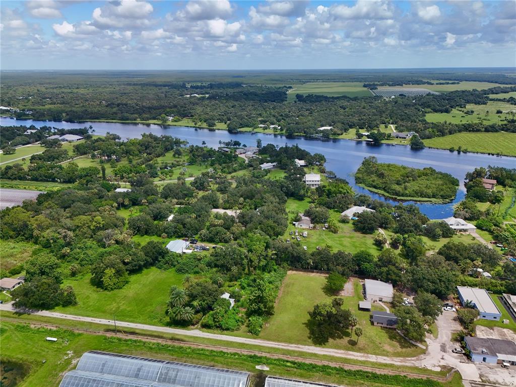 An aerial view shows a river winding through a rural landscape with scattered houses — 20101 WAGNER AVENUE, ALVA, FL