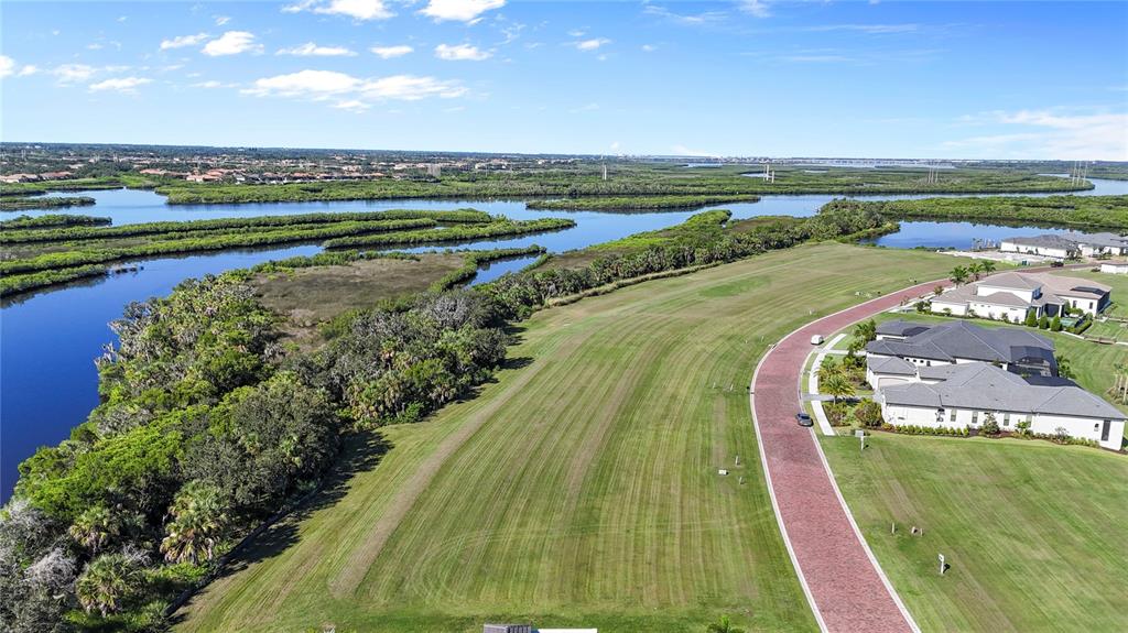An aerial view shows a grassy lot next to a road and waterfront mangroves — 1632 RIO VISTA TERRACE, PARRISH, FL