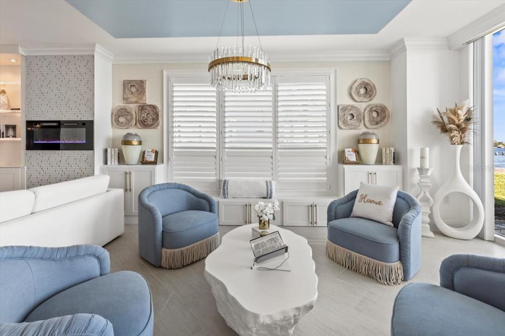 A living room features light blue armchairs, a white coffee table, and a fireplace — 231 RIVERSIDE DRIVE UNIT 102, HOLLY HILL, FL