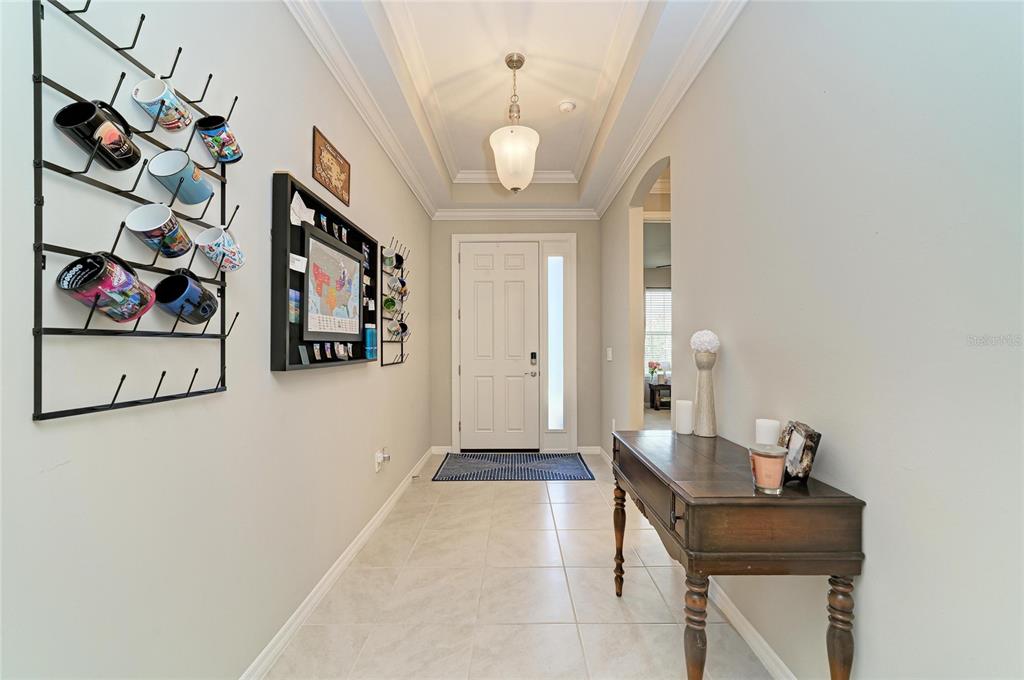 A tiled entryway features a mug rack, a console table, and a white front door — 174 VERAZA COURT, NOKOMIS, FL
