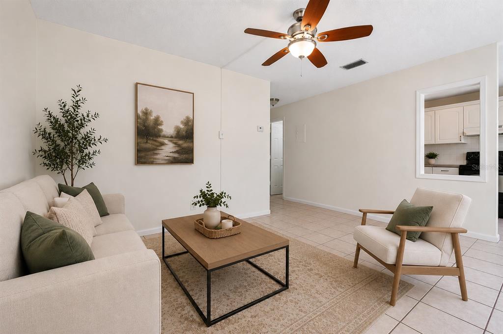 A living room features a beige sofa, a wooden coffee table, and a matching armchair — 5225 PEACH AVENUE, SEFFNER, FL