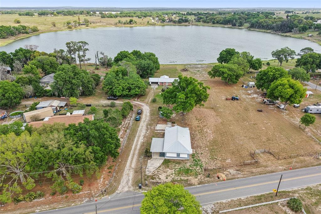 An aerial view shows two houses on a large lot next to a lake — 3070 E CENTRAL AVENUE, BARTOW, FL
