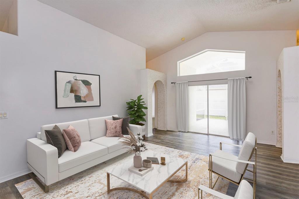 A living room with white walls, a white sofa, two armchairs, and a sliding glass door — 4655 CHEYENNE POINT TRAIL, KISSIMMEE, FL