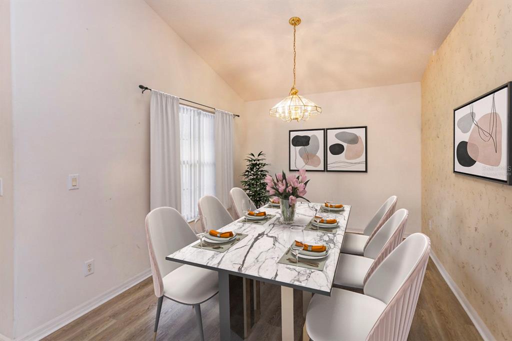 A dining room features a marble-topped table, six white chairs, and a gold pendant light — 4655 CHEYENNE POINT TRAIL, KISSIMMEE, FL