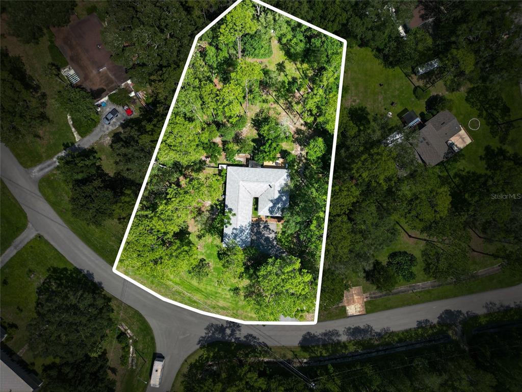 An aerial view shows a house on a large, wooded lot outlined in white — 325 NW 80TH BOULEVARD, GAINESVILLE, FL