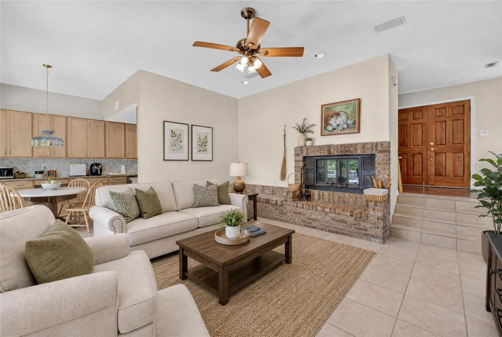 A living room features a brick fireplace, a beige sofa, and tile flooring — 325 NW 80TH BOULEVARD, GAINESVILLE, FL