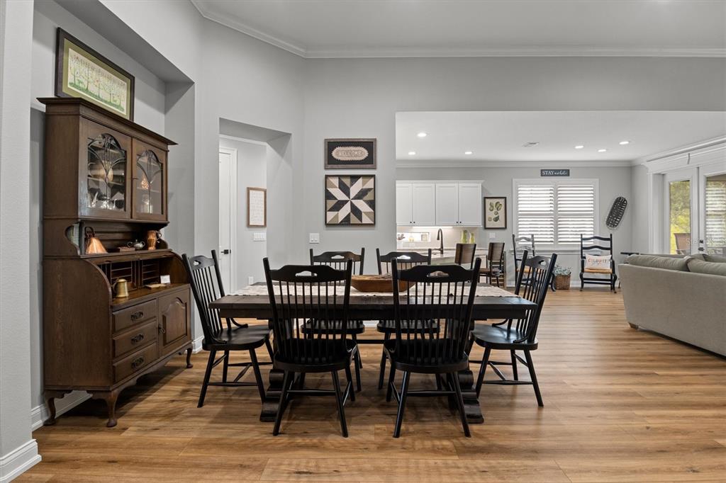 A dining room with a wooden hutch, dark chairs, and a table sits before an open kitchen — 7953 LAKE JAMES BOULEVARD, LAKELAND, FL