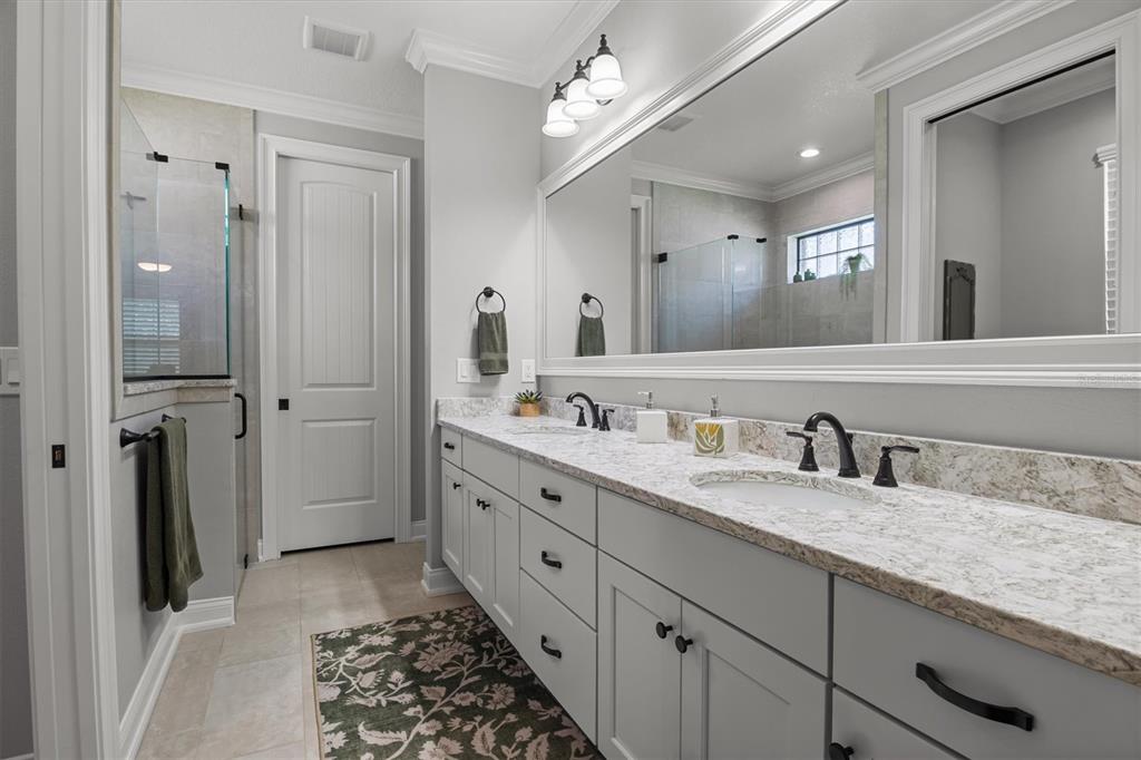 A bathroom features a double vanity with light gray cabinets, granite countertops, and a large mirror — 7953 LAKE JAMES BOULEVARD, LAKELAND, FL