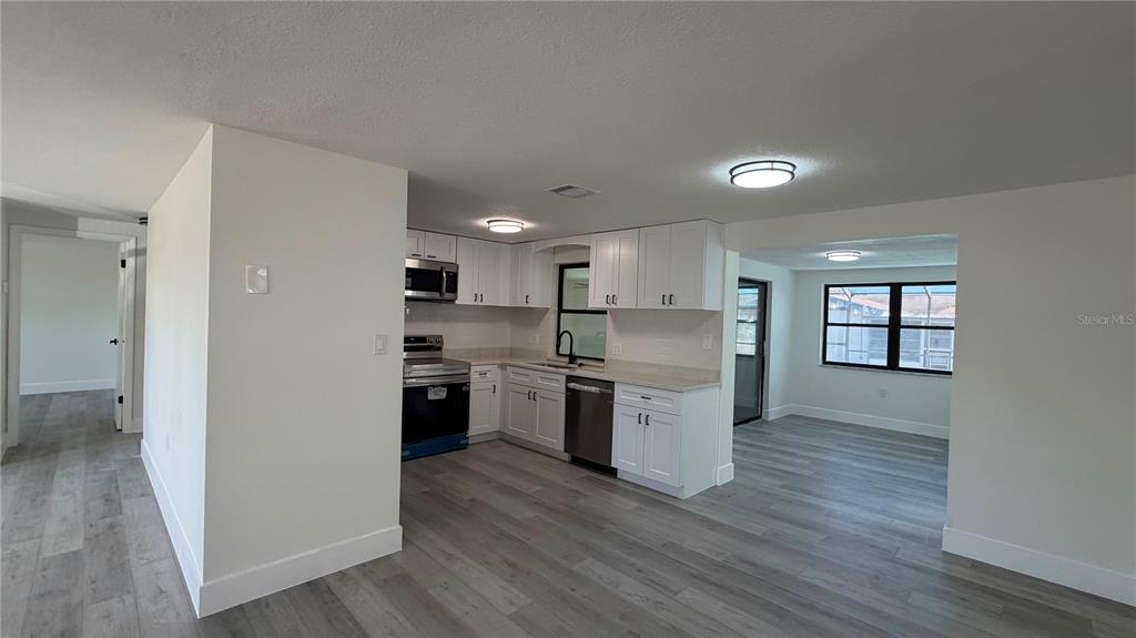 A covered entryway features a brick-paved floor, a dark wood door, and two chairs — 177 TRINITY RIDGE CIRCLE, DAVENPORT, FL