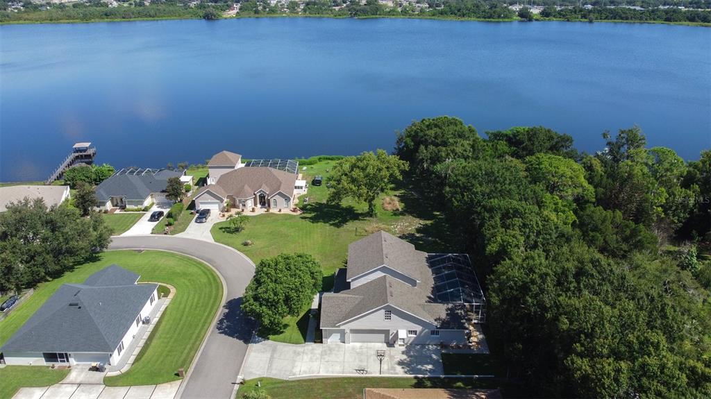 An aerial view shows several suburban houses with swimming pools situated along a large lake — 1016 S LAKE MARIAM DRIVE, WINTER HAVEN, FL
