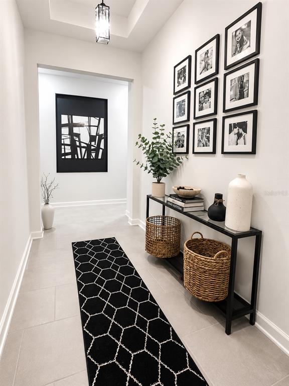 A modern hallway features a black geometric runner, a console table, and a gallery wall — 4514 HILLINGDAM ROAD, DAVENPORT, FL