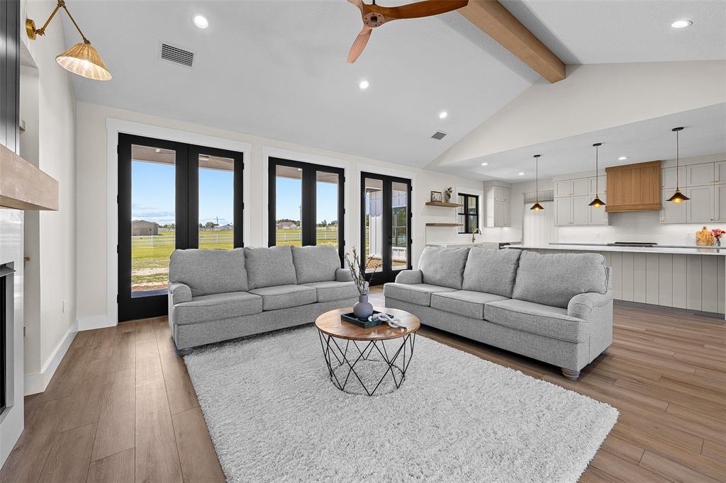 A living room features two gray sofas, a round coffee table, and an open kitchen — 845 NW COUNTRY LAKE DRIVE, LAKE CITY, FL