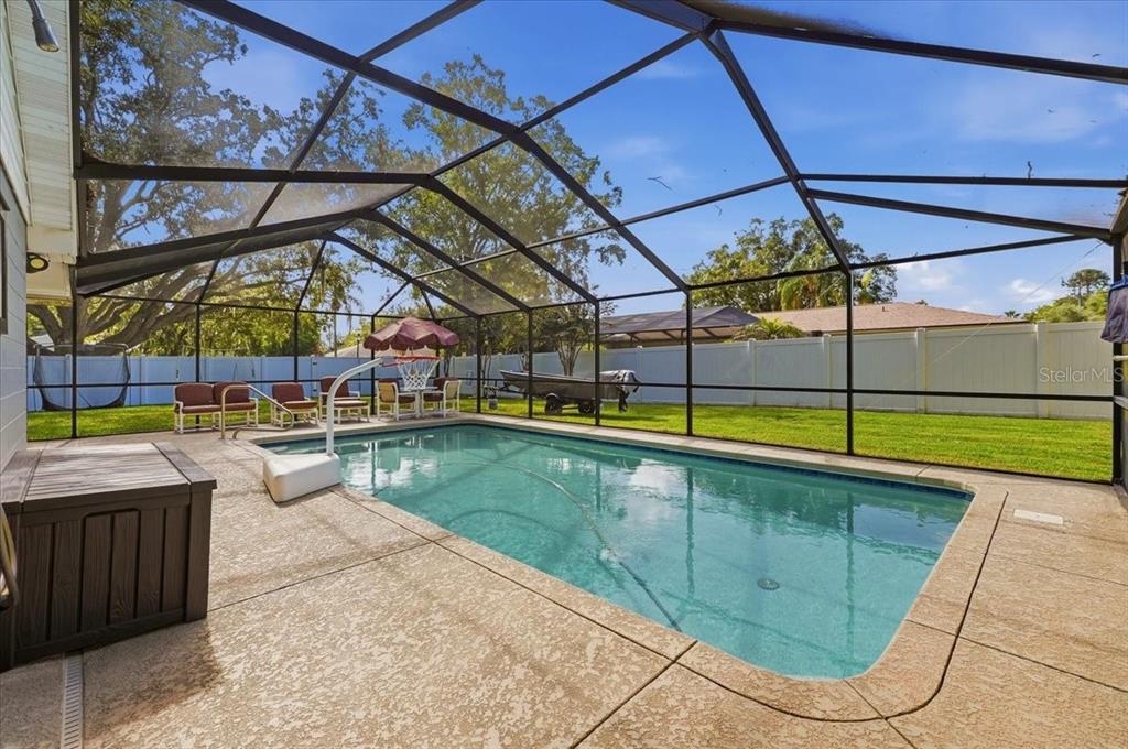 A screened-in swimming pool with a concrete deck and a fenced backyard — 2021 CHARNES DRIVE, LAKELAND, FL