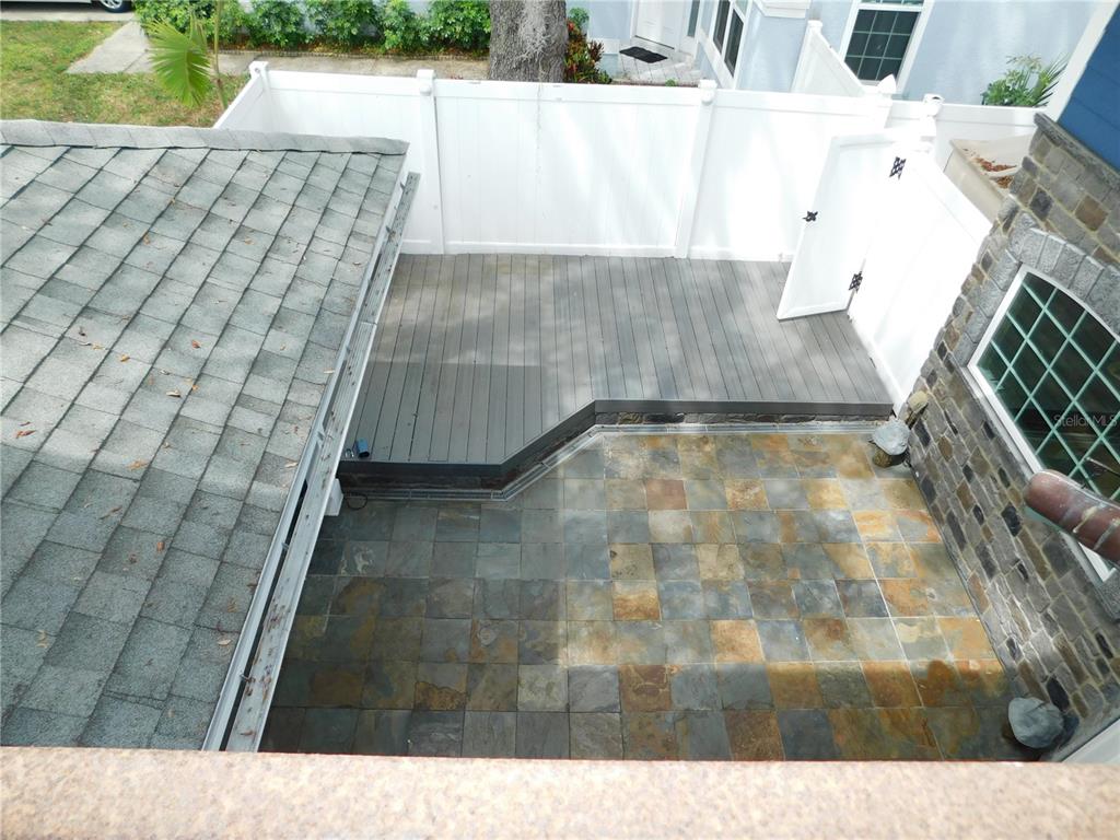 An elevated view shows a backyard with a gray wooden deck and stone patio — 155 MARSHALL STREET, SAFETY HARBOR, FL