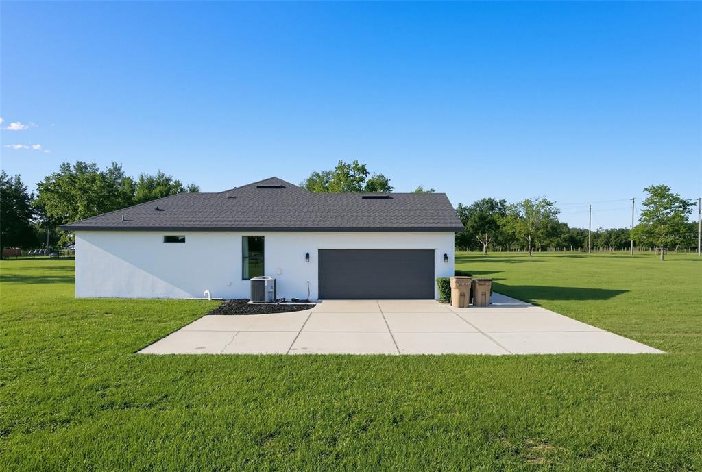 The exterior of a white house with a gray roof and a concrete driveway — 4650 LAKE PICKETT DRIVE, GROVELAND, FL