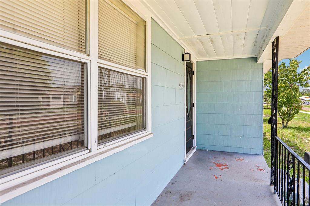 A light blue house exterior features a covered front porch, a window, and a door — 4500 3RD AVENUE S, ST PETERSBURG, FL