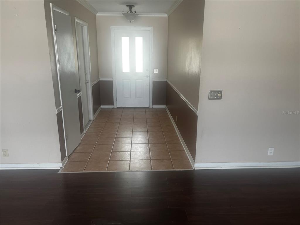 An entryway features a tiled floor, a white front door, and two-toned wall paint — 108 LAGOON ROAD, WINTER HAVEN, FL