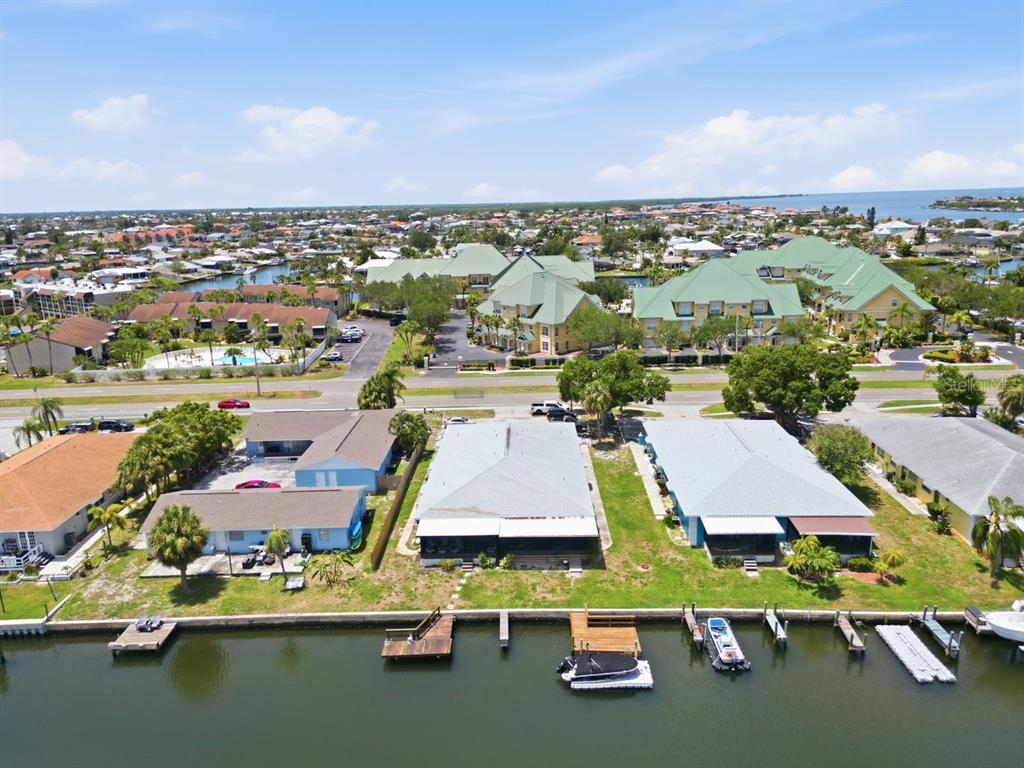 An aerial view shows waterfront houses with private docks along a canal near a resort — 1041 APOLLO BEACH BOULEVARD UNIT E, APOLLO BEACH, FL