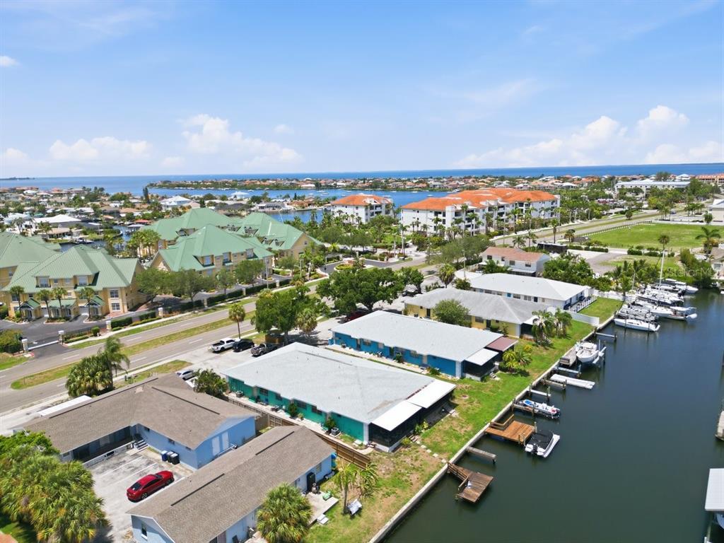 An aerial view shows waterfront residential buildings with boat slips along a canal — 1041 APOLLO BEACH BOULEVARD UNIT E, APOLLO BEACH, FL