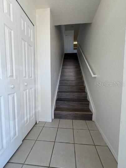 A tiled entryway features a white closet door on the left and stairs leading upward — 4850 51ST STREET W UNIT 1203, BRADENTON, FL