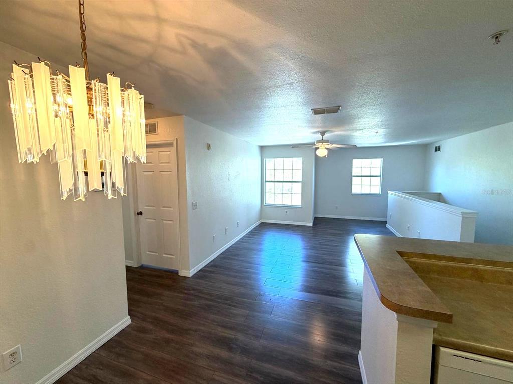 A view of a living area with wood-look flooring, a chandelier, and a ceiling fan — 4850 51ST STREET W UNIT 1203, BRADENTON, FL