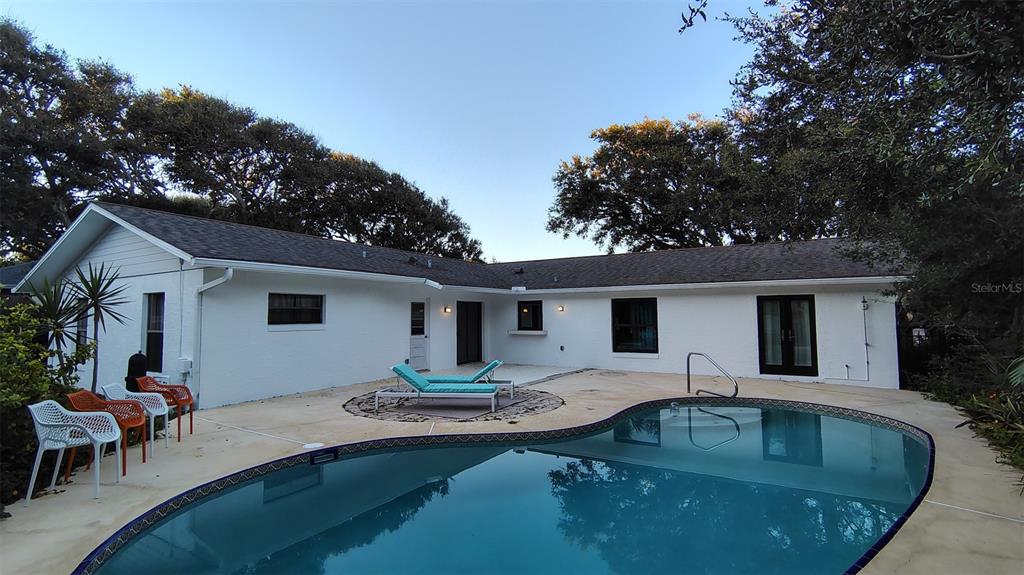 A white, single-story house with a backyard swimming pool and patio area — 4790 MICHAEL LANE, PONCE INLET, FL