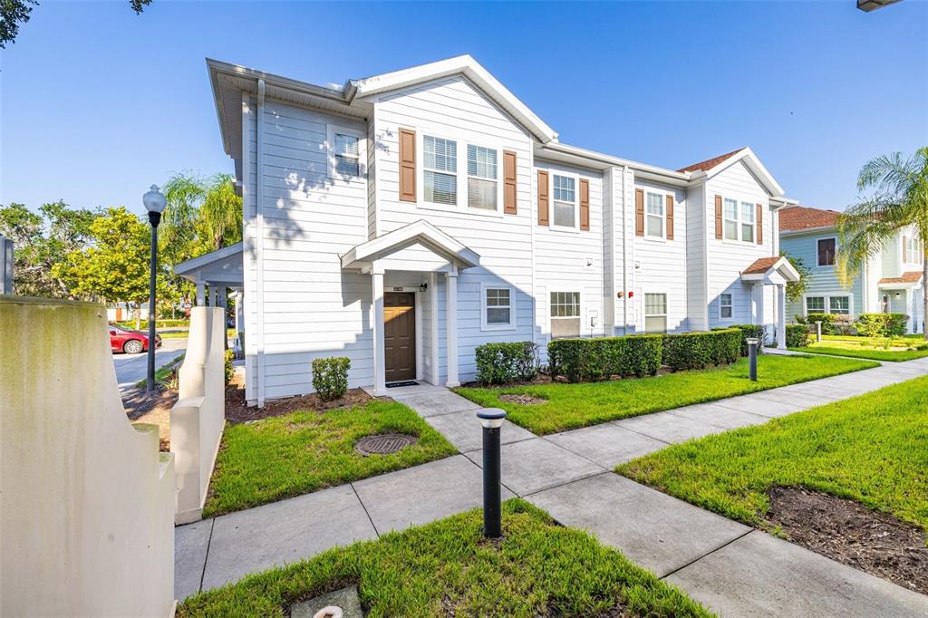 A two-story white siding townhouse with brown shutters and a front walkway — 5370 DIPLOMAT COURT UNIT 108, KISSIMMEE, FL