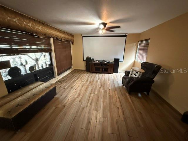 A living room features wood-look flooring, a projector screen, and a dark leather armchair — 1605 NE 38TH TERRACE, OCALA, FL