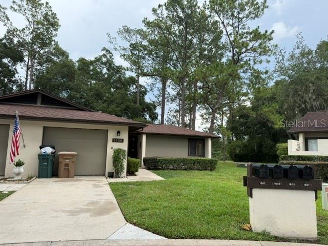 A single-story residential building with a garage, a driveway, and a cluster of mailboxes — 1605 NE 38TH TERRACE, OCALA, FL