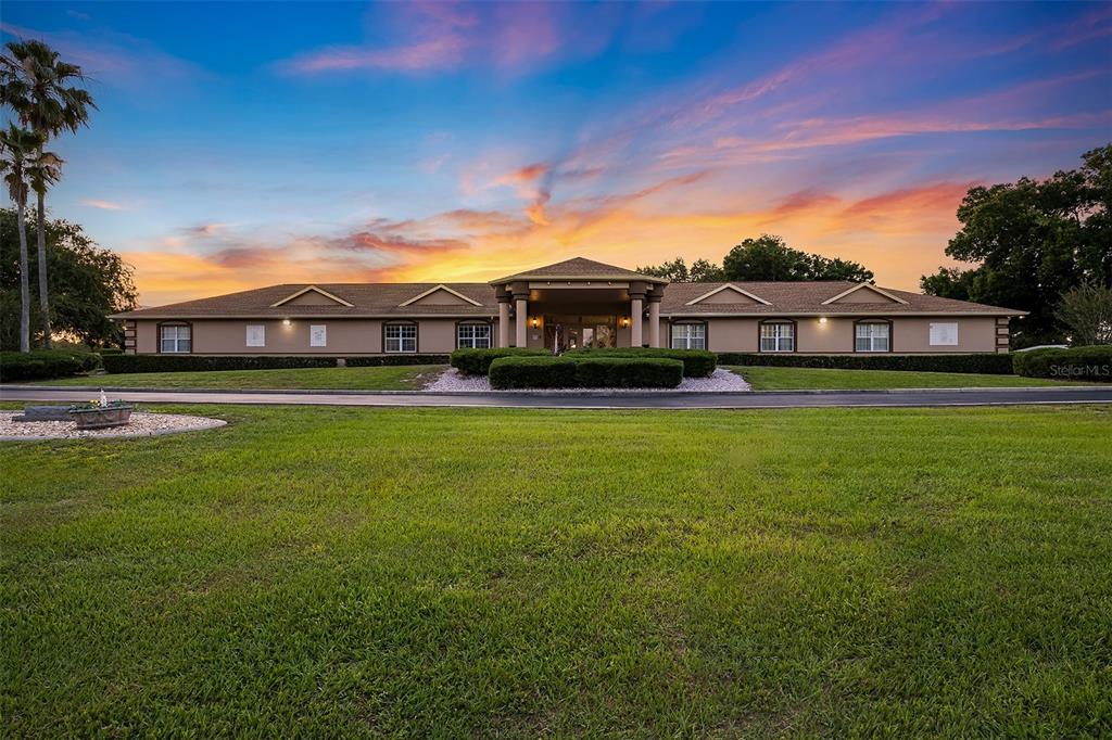 A wide, single-story building with a covered entrance sits behind a large, grassy lawn — 6093 SW 96TH PLACE, OCALA, FL
