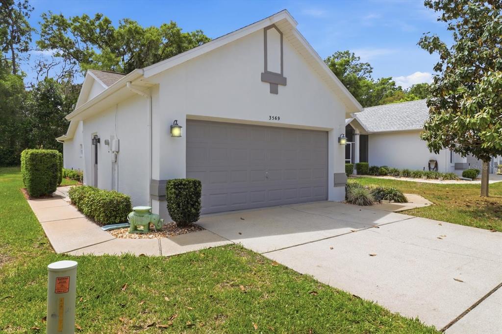 A white house with a gray garage door and a concrete driveway — 3569 S BELGRAVE DRIVE, INVERNESS, FL