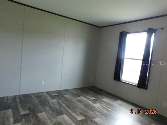An empty room features light-colored walls, dark trim, and wood-look flooring with a single window — 8236 SWEDEN BOULEVARD, PUNTA GORDA, FL