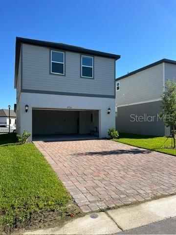 A two-story house features a paved driveway leading to an open garage — 4716 HOMESTEAD TRAIL, ST CLOUD, FL