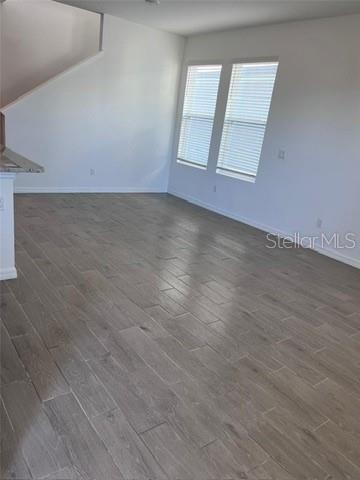 An empty room with light-colored wood-look tile flooring, white walls, and two windows — 4716 HOMESTEAD TRAIL, ST CLOUD, FL