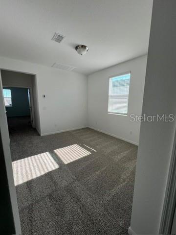 An empty bedroom features gray carpeting, white walls, a ceiling light, and a single window — 4716 HOMESTEAD TRAIL, ST CLOUD, FL
