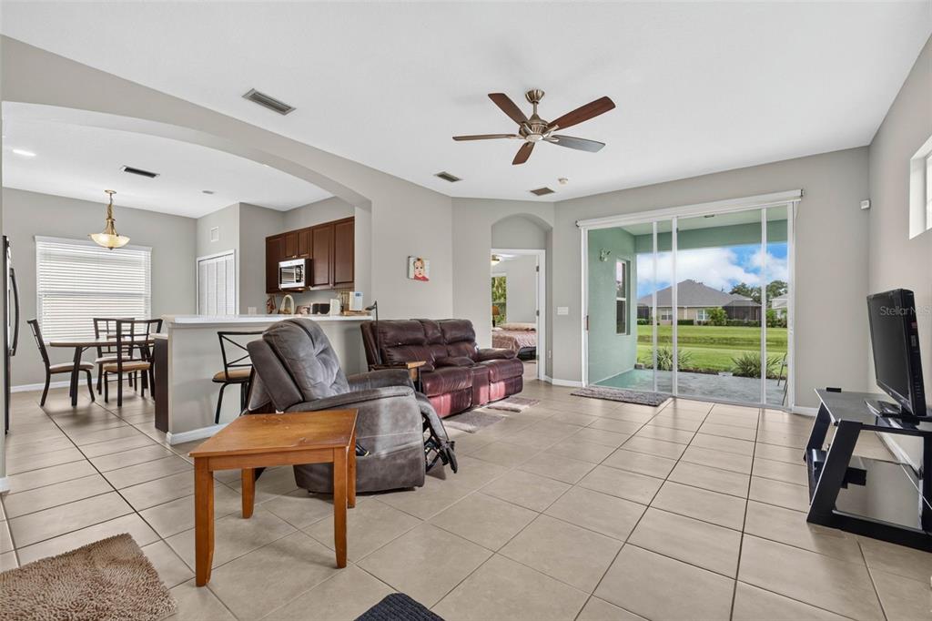 A living room with tile floors, a ceiling fan, and sliding glass doors to a patio — 4134 DEEP CREEK TERRACE, PARRISH, FL