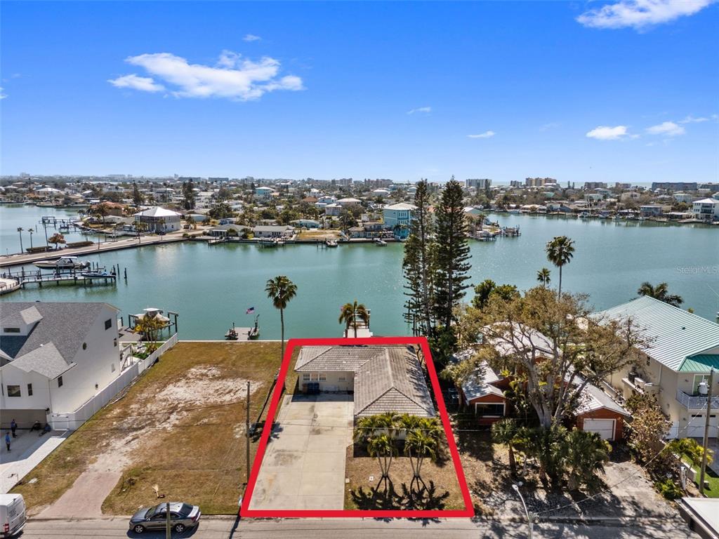 An aerial view shows a waterfront house with a concrete driveway and a red outline — 837 BAY POINT DRIVE, MADEIRA BEACH, FL