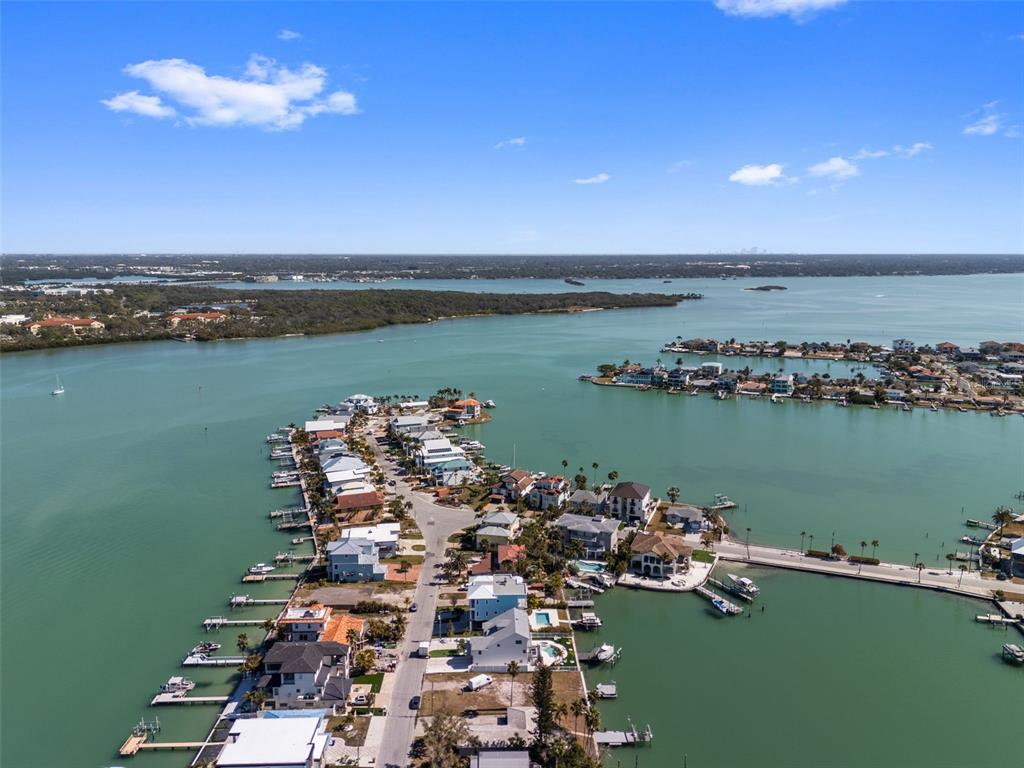 An aerial view of a residential peninsula surrounded by water with numerous private boat docks — 837 BAY POINT DRIVE, MADEIRA BEACH, FL