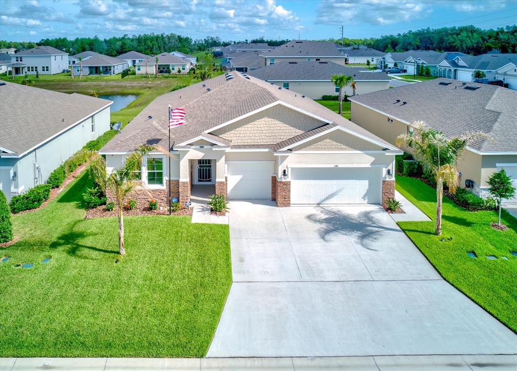 An aerial view of a single-story suburban house with a concrete driveway and palm trees — 345 E MERIMONT LANE, ORMOND BEACH, FL